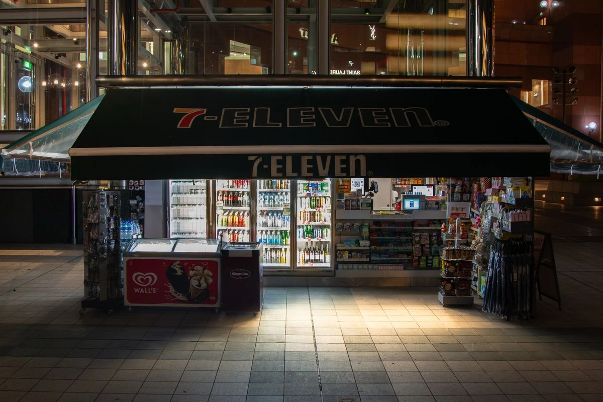 深夜燈火通明的 24 小時便利商店與 ATM，象徵全天候調度資金的管道