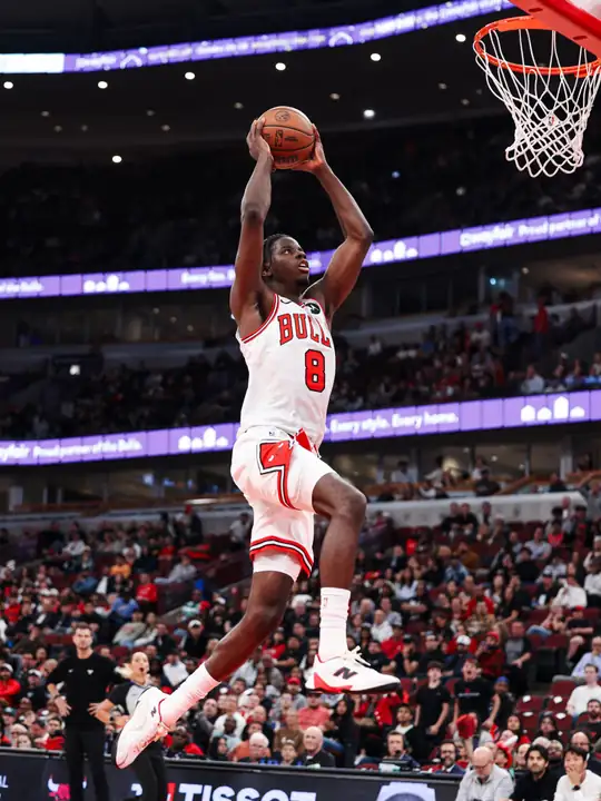 公牛官方 Instagram 貼文：身穿公牛白色 8 號球衣的 Caleb Wilson 在 United Center 雙手持球騰空準備灌籃